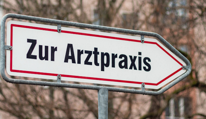 Ein Foto von einem Wegweiser-Schild zu einer Arztpraxis